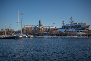 Fototapeta premium Panorama view over a snowy Stockholm inner harbour a sunny winterday with boats and landmarks