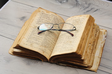 Open book with optical glasses. Old medieval Bible in Armenian language. selective focus, shallow depth of field, not protected by copyright