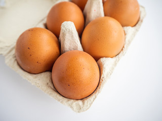 Brown eggs in a package and white background.  Easter concept. Top view 