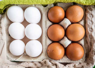 White and brown eggs in a package and kitchen towel.  Easter concept. Top view 