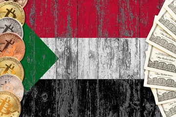 Sudan savings concept. Bitcoins and dollar banknotes on the side of national flag with wooden background. Trading currencies.