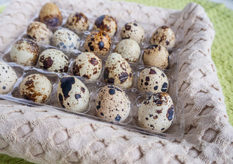 Obraz premium quail eggs in package in a towel. Easter concept. Top view, brown background 