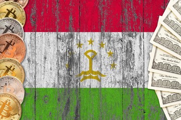 Tajikistan savings concept. Bitcoins and dollar banknotes on the side of national flag with wooden background. Trading currencies.