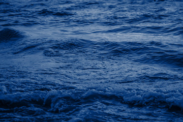 Navy classic blue sea water texture. Classic blue pool water with sun reflections. Trendy colour 2020 year. Classic blue background. Dark classic blue sea wave. Abstract monochrome texture. Color 2020