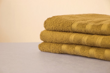 Obraz na płótnie Canvas pile of clean terry bath yellow towels, close-up, on a light background, copy space, concept of cleanliness, bath procedure, spa
