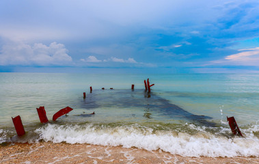 Old ruined pier hidden by sea waves. 