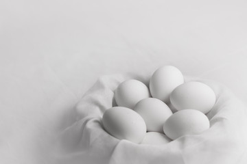 bunch of white eggs in cloth nest close up