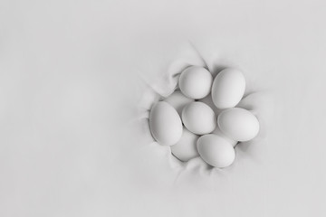 bunch of white eggs in cloth nest flat lay