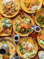 Fototapeta na wymiar Authentic Thai cuisine. Spicy and pungent Asian food such as papaya salad, tom yum soup, shrimp prawn pad thai, and chicken drunken noodles.