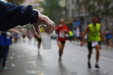 A plastic cup of water on offer for runners at a marathon