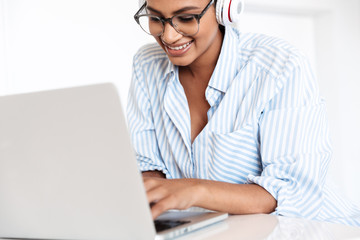 Attractive young african woman working on laptop computer