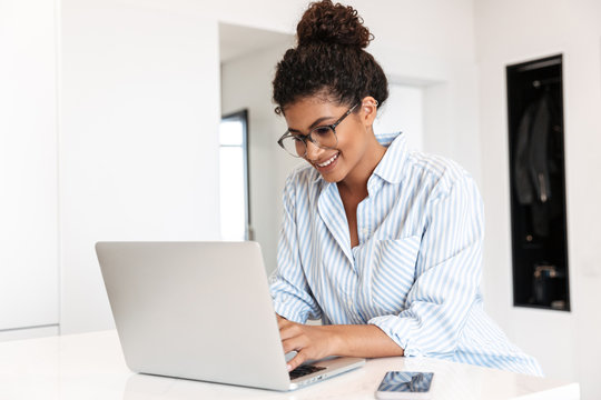 Attractive young african woman working on laptop computer