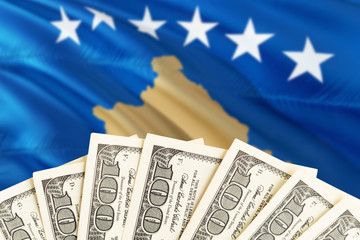 Kosovo economy concept. Dollar banknotes on the side of national flag with waving background....
