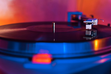 Fototapeta premium vinyl needle on a record in blue and orange tones. selective focus