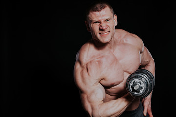Fototapeta na wymiar Sport the athlete bodybuilder build muscles dumbbells