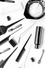 hair dye with brush on white table background top view