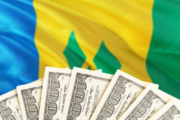 Saint Vincent And The Grenadines economy concept. Dollar banknotes on the side of national flag...