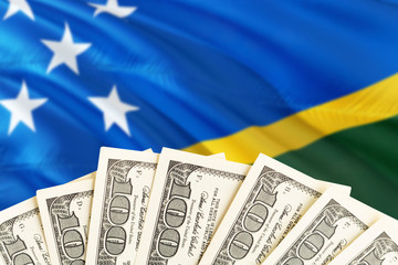 Solomon Islands economy concept. Dollar banknotes on the side of national flag with waving...