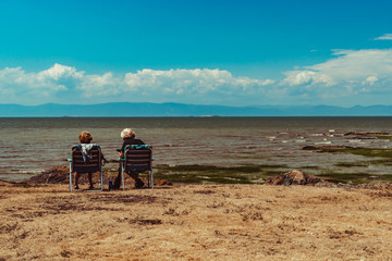 Ladies sitting at the water's edge looking at the horizon