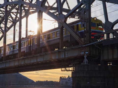 A passenger train is leaving Riga Central Station at sunset on a cold day in March 2017