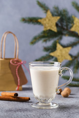 Christmas background with, gift boxes, stars, festive decor, fir tree, cinnamon sticks, hot eggnog drink.