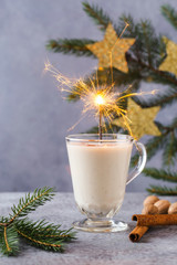 Christmas background with, gift boxes, stars, festive decor, fir tree, cinnamon sticks, hot eggnog drink.