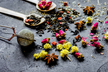 Spoons and herbs on grey background