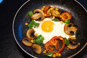 Freshly fried eggs with vegetables in a pan