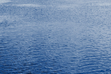 Navy classic blue sea water texture. Classic blue pool water with sun reflections. Trendy colour 2020 year. Classic blue background. Dark classic blue sea wave. Abstract monochrome texture. Color 2020