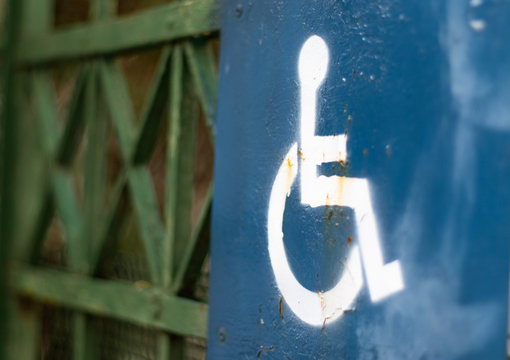Rusty ruined sign of disabled handicap icon, concept of disabilites and unfairness and discrimination