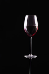 Glass of red wine on black background. Aromatic wine. Strict style. Wine on the dark