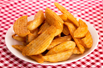 Plate of Spiced Potato Wedges on a Red Gingham Table Cloth