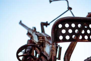 Low caliber rusted abandoned old anti air gun pointed towards the air, remains of world war 2