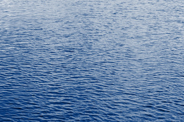 Navy classic blue sea water texture. Classic blue pool water with sun reflections. Trendy colour 2020 year. Classic blue background. Dark classic blue sea wave. Abstract monochrome texture. Color 2020
