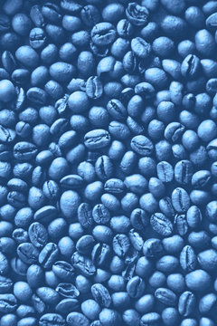 Background of classic blue color coffee beans. Monochrome coffee beans texture. Coffee beans classic blue background. Trendy color 2020. Out focus. © kizuneko
