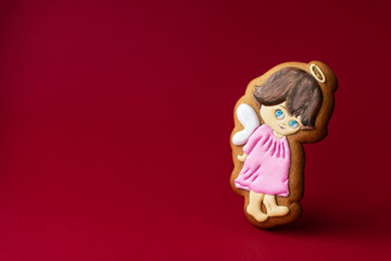 gingerbread cookie of little cute angels on red background. Traditional Christmas food. Christmas and New Year holiday concept.