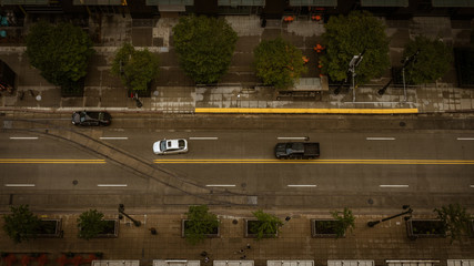 Aerial Top down view of vehicles driving down a city street