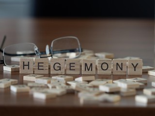 hegemony the word or concept represented by wooden letter tiles - obrazy, fototapety, plakaty