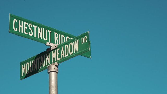 4K. Close up green plate of Mountain Meadow in a street of Simi Valley, California. Clear blue sky in one of the streets of the village of Moorpark. Green street sign in Los Angeles. Cinema effect.