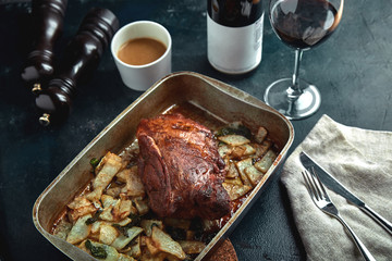 Baked meat and potatoes. A delicious and hearty meal. A large baked piece of meat. Cooked hot food.