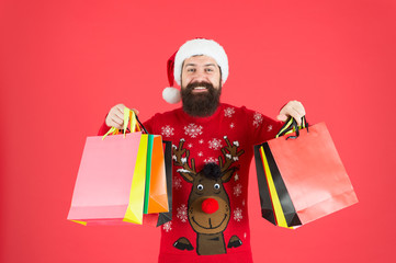 Keep calm and carry on. Bearded man hold shopping bags. Happy hipster carry paper bags. Holiday purchases in colorful bags. Winter sale and discount. Christmas and New Year preparation. Grab bags