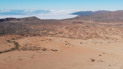 Fototapeta na wymiar Aerial view of desert in mountains above the clouds
