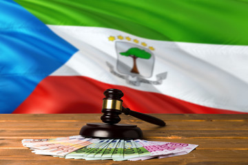 Equatorial Guinea bribing concept. Law theme, mallet of the judge on wooden desk with national flag background.