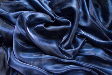 Background fabric folds dark blue tulle or organza, selective focus