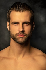 Obraz premium Handsome sport sexy stripped guy portrait for cosmetics and fitness on isolated black background