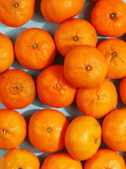 Juicy ripe tangerines on a blue background. View from above