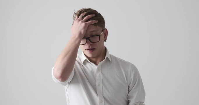 Businessman knocking his head and regretting wrongdoing over white background