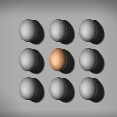 Colored brown egg between gray eggs. individuality concept. different color egg.