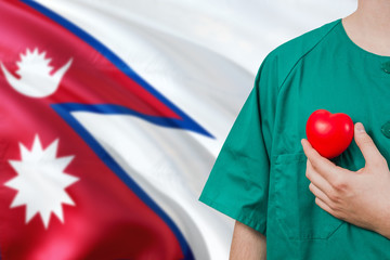 Nepal veterinary clinic concept. Veterinarian is holding plastic heart in green uniform on national...