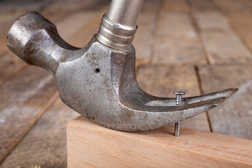 Pulling out nails from a piece of wood using a carpenter's hammer. Small carpentry work in the...